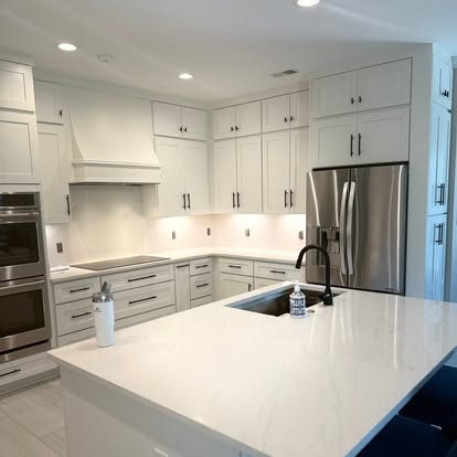 A white kitchen with a waterfall island