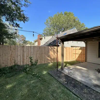 A cedar fence along a covered back patio