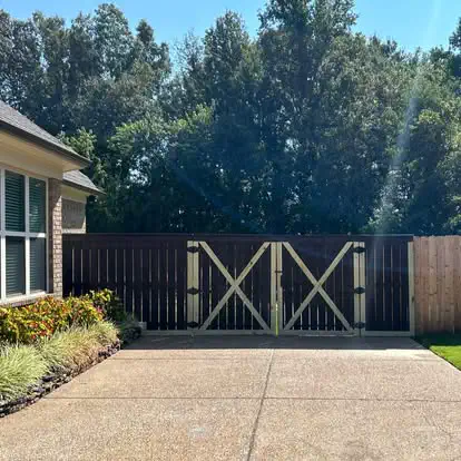 A dark stained fence with a double drive gate